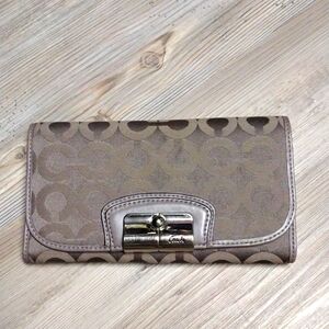 A coach snap wallet. With an inside cash wallet with a pen holder.